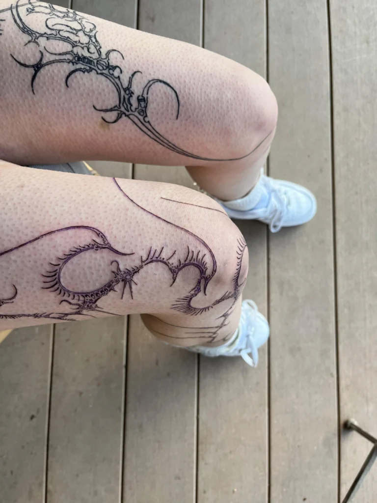 Linework-Tattoos von Thierry Bill auf beiden Knien, von oben fotografiert